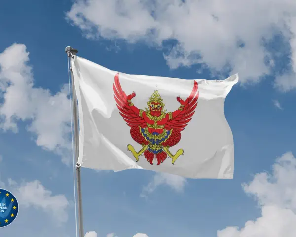 Biała flaga z wizerunkiem czerwonego Garudy, symbolu Tajlandii, powiewa na tle błękitnego nieba z chmurami.