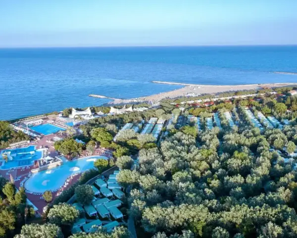 Widok z lotu ptaka na **camping Isamar** z basenami, domkami kempingowymi i plażą nad morzem.