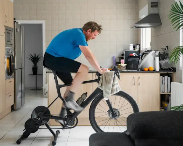 Man doing indoor cycling for beginners in his kitchen.