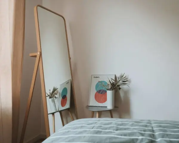 Lustro odbija plakat z kołami i wazon z suszonymi kwiatami. To inspiracja do stworzenia własnej konmari listy porządków.