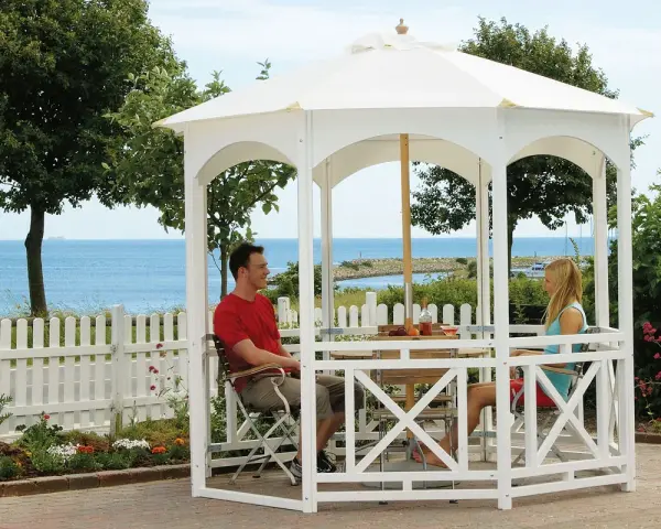 Ett par njuter av utsikten vid havet under en vit paviljong. Perfekt för att bygga paviljong och skapa en avkopplande oas.