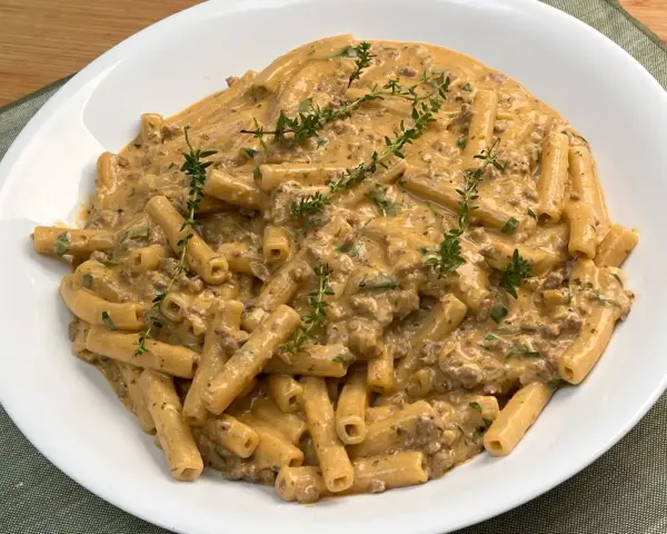 Piatto di pasta alla montecarlo con ragù cremoso e timo fresco.