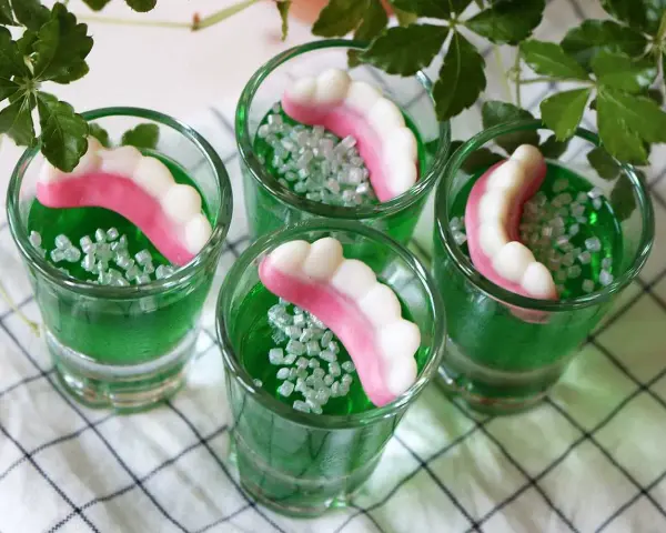 Gröna jello shots med godiständer och strössel. Perfekt för en festlig stämning!