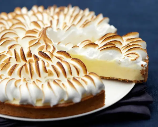 Une délicieuse recette tarte au citron avec une meringue dorée et aérienne, prête à être dégustée.