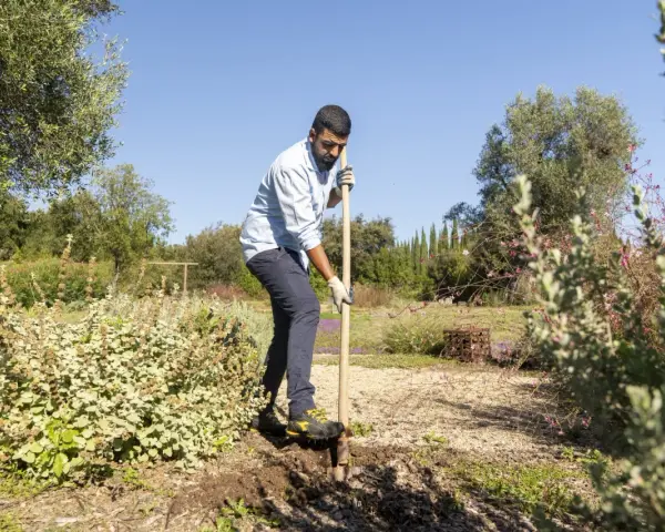 Uomo con pala in un giardino, forse per preparare il terreno con greenex nf dosaggio.