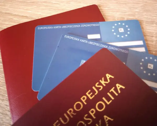 Czerwony paszport i dwie niebieskie karty EKUZ Konin, gotowe na podróż po Europie.