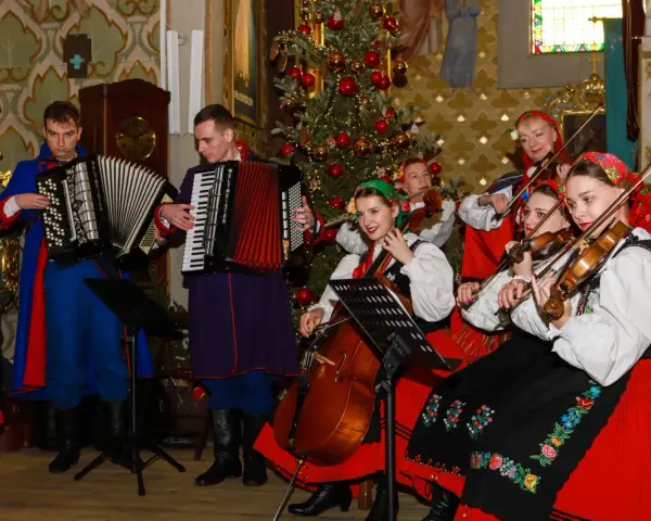 Zespół w strojach ludowych grający wszystkie kolędy polskie przy choince.