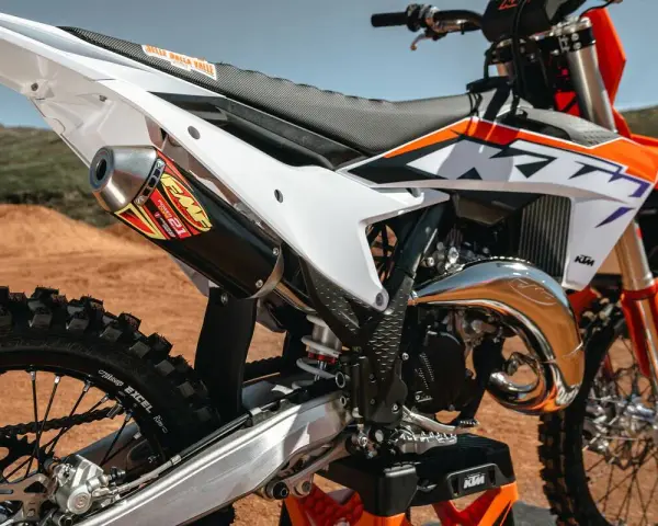 Scarico FMF su KTM arancione e bianca. La moto da cross, con il suo motore 2t, è pronta per la pista.