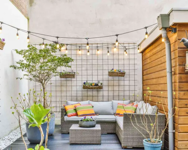 Piccole verande arredate con divano, tavolino e piante. Luci decorative creano un'atmosfera accogliente.