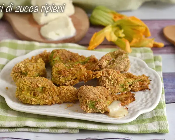 Fiori di zucca ripieni al forno, dorati e croccanti, con un cuore filante di mozzarella.