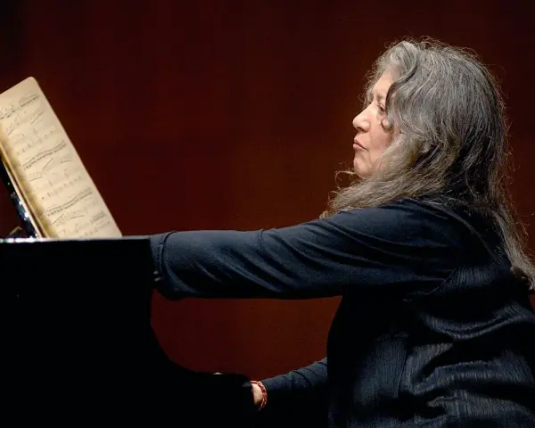 Martha Argerich, pianistka o argentyńskim pochodzeniu, gra na fortepianie, wpatrzona w nuty.