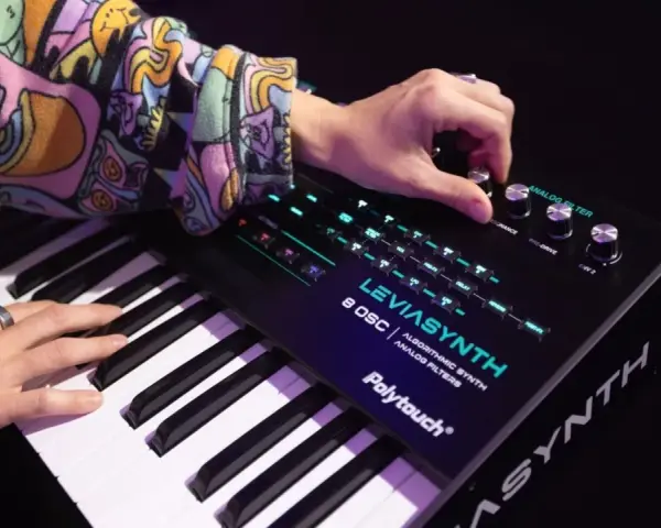Ręce grają na syntezatorze LEVIASYNTH, tworząc dźwięki, które mogą wywołać efekt glitch sound.
