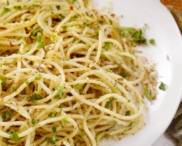Un piatto di spaghetti conditi con aglio, olio, peperoncino e prezzemolo, un classico della pasta alla carrettiera.