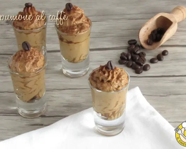 Delizioso spumone al caffè in bicchierini, guarnito con chicchi di caffè e cacao. Perfetto per una pausa golosa.