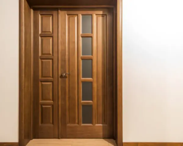 Puertas dobles de madera con paneles y vidrio, ideales para inspirarte sobre como elegir el color de las puertas de interior.