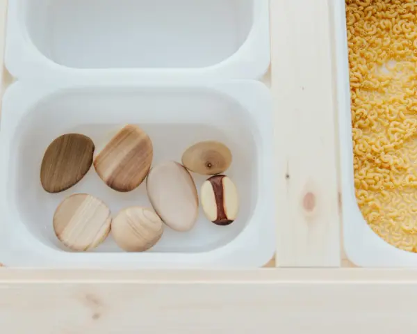 Drewniane kamienie i makaron tworzą ciekawą ścieżkę sensoryczną w ogrodzie.