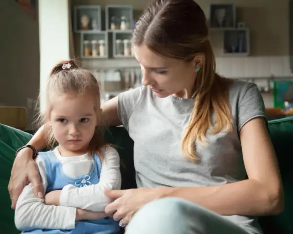 Mama próbuje uspokoić obrażone dziecko, które nie chce słuchać.