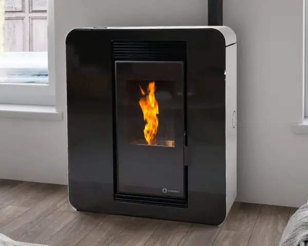 Chimenea estufa pellets moderna, con llama viva en su interior, junto a una ventana.