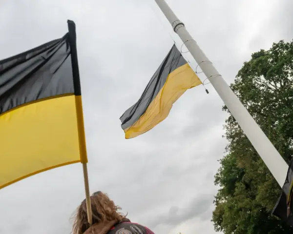 Flaga Kaszub powiewa na wietrze, symbol dumy i tożsamości.