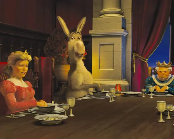 Królowa Fiona, Osioł i Król Harold siedzą przy stole. Scena z filmu DreamWorks.