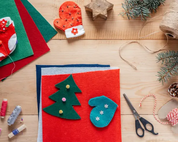 Materiały do tworzenia świątecznych kartki diy: filc, sznurek, igły, nożyczki, koraliki i ozdoby.