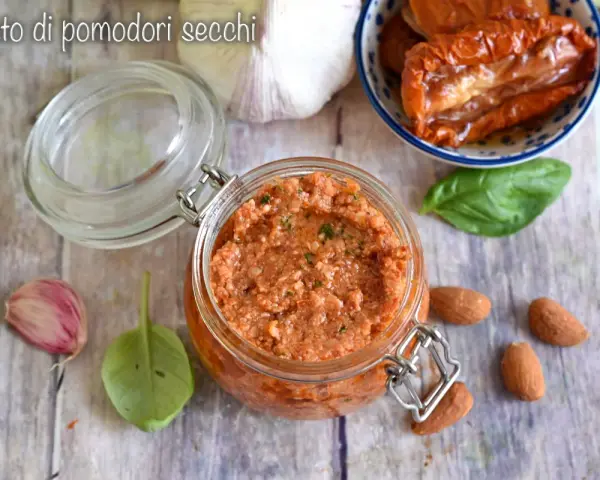 Un vasetto di pesto di pomodori secchi, con mandorle, aglio e basilico, pronto per insaporire i tuoi piatti.