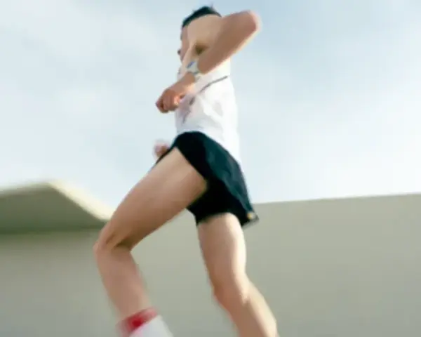 Un atleta corre a tutta velocità, mostrando quanto corre veloce un uomo. Le gambe muscolose si muovono rapidamente, catturando l'essenza della velocità.