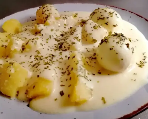 Jajka w sosie musztardowym z ziemniakami, posypane ziołami. Pyszne danie, które zachwyci każdego smakosza.