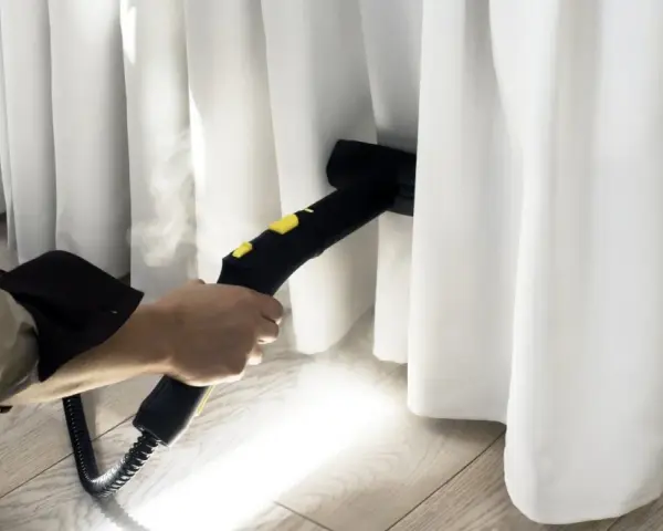 Limpieza profunda de cortinas blancas con vapor. El vaporizador elimina manchas y desinfecta, dejando las cortinas impecables.