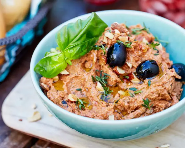 Herzhafte Dip Rezepte: Cremiger Dip mit Oliven, Mandeln und Basilikum, beträufelt mit Olivenöl. Perfekt zum Dippen!
