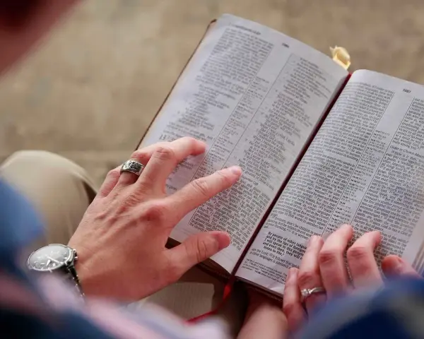 Hände halten eine Bibel. Eine Frage ist, ob Jesus Gott ist.