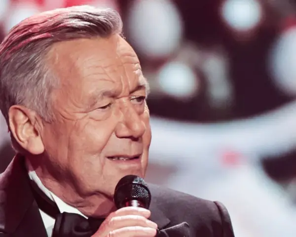 Roland Kaiser singt mit Mikrofon, im Anzug mit Fliege.