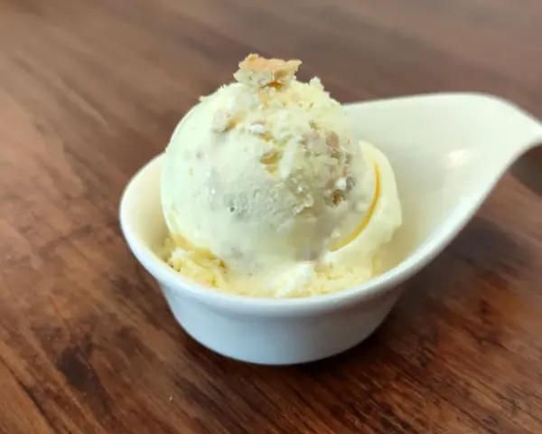 Cremiges Butterkeks Eis in einer weißen Schale, garniert mit Butterkeks-Krümeln. Ein Genuss für warme Tage.
