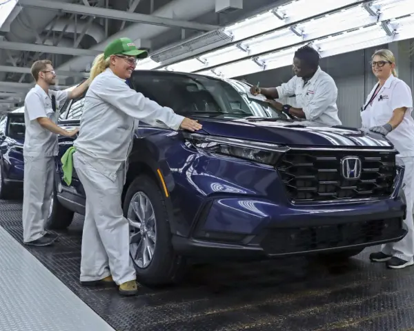 Pracownicy w fabryce Hondy z Japonii kontrolują nowy, ciemnoniebieski SUV.