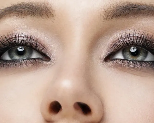 Oczy z makijażem smoky eyes, podkreślone długimi rzęsami i błyszczącym cieniem.