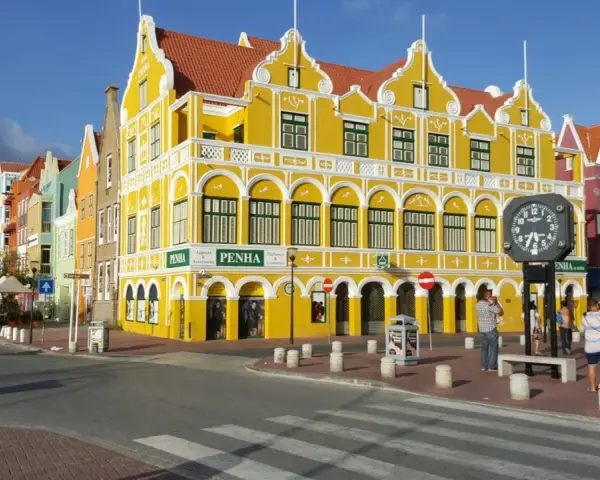 Kolorowe, zabytkowe budynki w stylu wielkich antyli, z dominującym żółtym budynkiem PENHA, tworzą malowniczy krajobraz miejski.