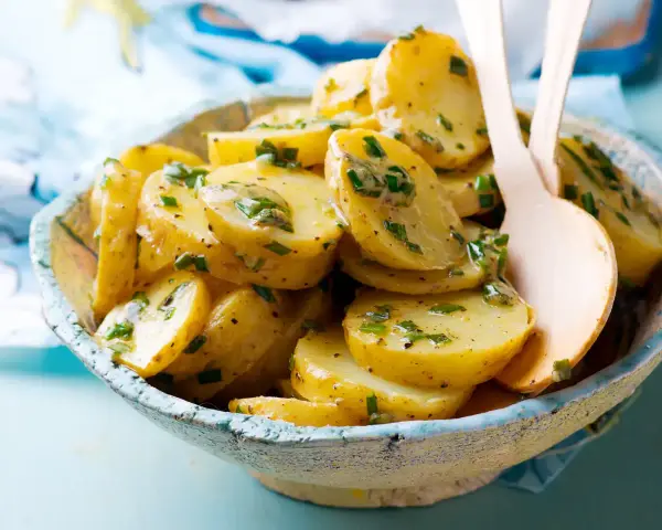 Salade de pommes de terre aux herbes fraîches, nappée d'une vinaigrette savoureuse. Un délice pour accompagner vos repas.