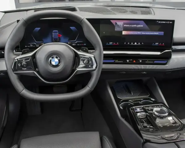 Wnętrze BMW 520d xDrive z nowoczesnym ekranem i kierownicą.