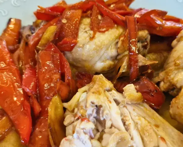Succulento pollo alla romana con peperoni rossi arrostiti, un piatto saporito e colorato.