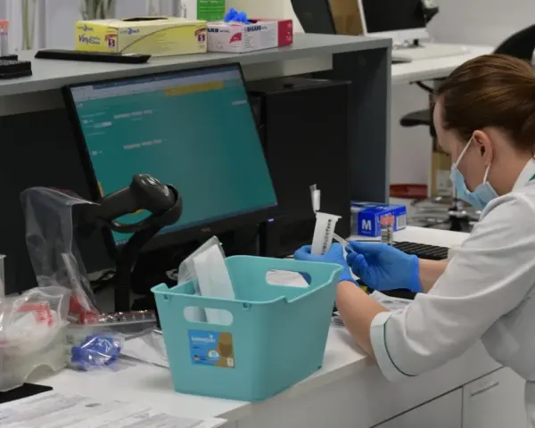 Pracownik laboratorium w maseczce i rękawiczkach przygotowuje próbki. Czy diagnostyka to dobre laboratorium? Tak, to miejsce precyzji.