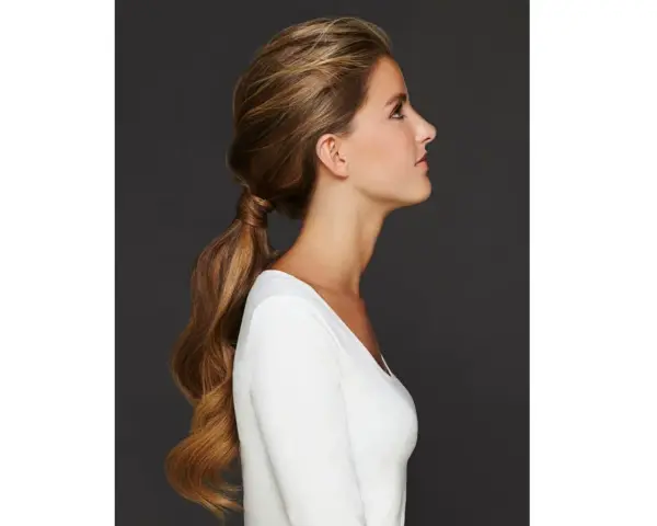 Capelli lunghi e mossi raccolti in una coda bassa, un'idea per semplici acconciature matrimonio invitata.