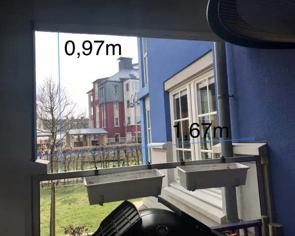 Mått för att bygga vindskydd: 0,97m och 1,67m. Utsikt över radhus och trädgård.