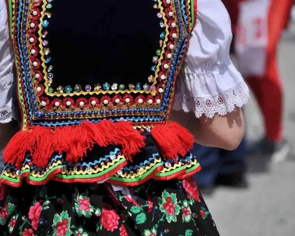 Kolorowy strój ludowy, ozdobiony koralikami i haftem, zapowiada radosne tańce ludowe.