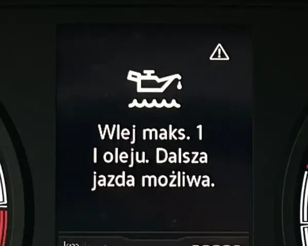 Na desce rozdzielczej migająca kontrolka oleju z komunikatem "Wlej maks. 1 l oleju. Dalsza jazda możliwa." ostrzega o niskim poziomie smarowania.