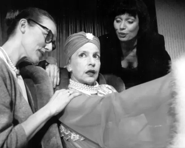 Marlena Milwiw młoda, w otoczeniu dwóch kobiet, w teatralnej scenie.