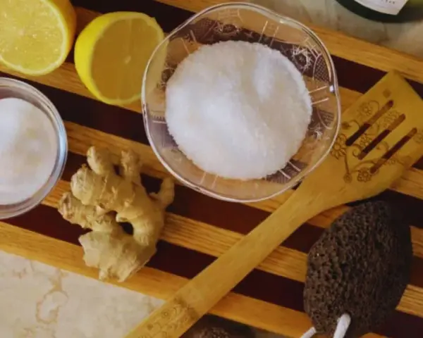 Ingredients for a homemade foot soak to remove dead skin: lemons, ginger, sugar, and a pumice stone.