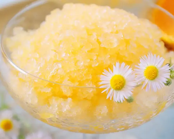 Erfrischendes Zitronen-Granita-Rezept in einem Glas, garniert mit Gänseblümchen. Perfekt für heiße Tage!