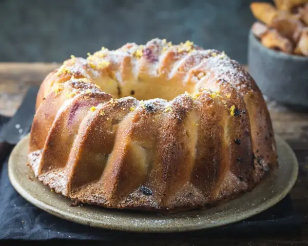 Wilgotna babka piaskowa Ewy Gotuje, posypana cukrem pudrem i skórką cytrynową, wygląda apetycznie.
