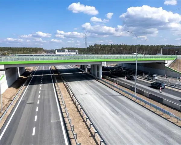 Nowa autostrada A6 z zielonym wiaduktem i ruchem samochodowym.