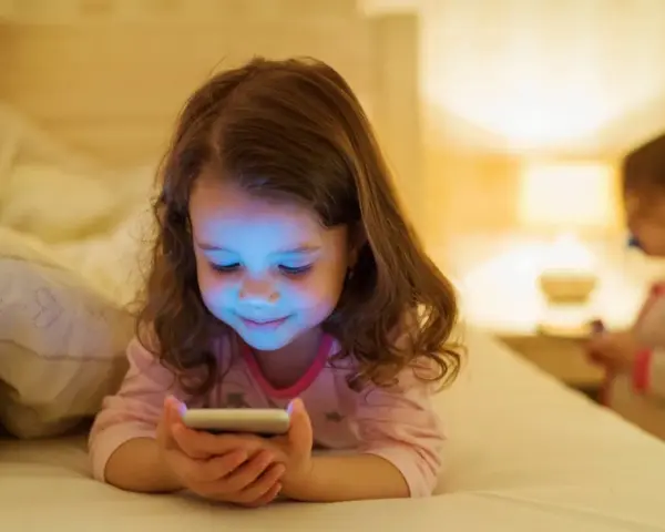 Dziewczynka zafascynowana ekranem telefonu. Jak odzwyczaić dziecko od telefonu? Czas na alternatywy!